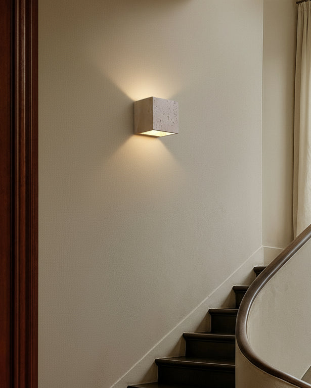 Stairwell with a wall-mounted light fixture on a neutral-colored wall.