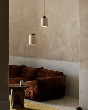 Modern interior with a brown sofa, round table, and pendant lights.